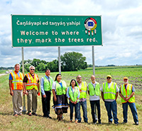 This new Dakota-English language sign welcomes travelers to the Lower Sioux Indian Community in District 8. The sign reads 'Welcome to where they mark the trees red.'